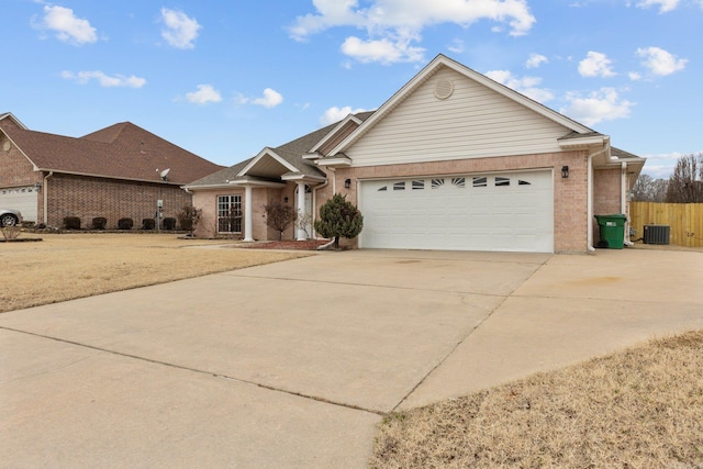 ranch-style home with a garage and central air condition unit