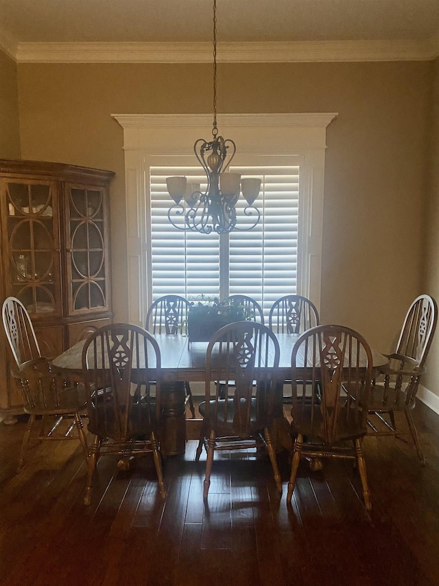 dining room with ornamental molding, dark hardwood / wood-style flooring, and a chandelier