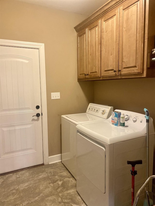 washroom with cabinets and washing machine and dryer