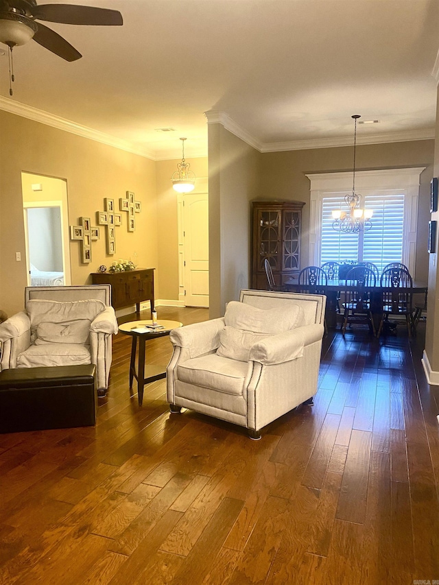 living room with crown molding, dark hardwood / wood-style flooring, and ceiling fan with notable chandelier