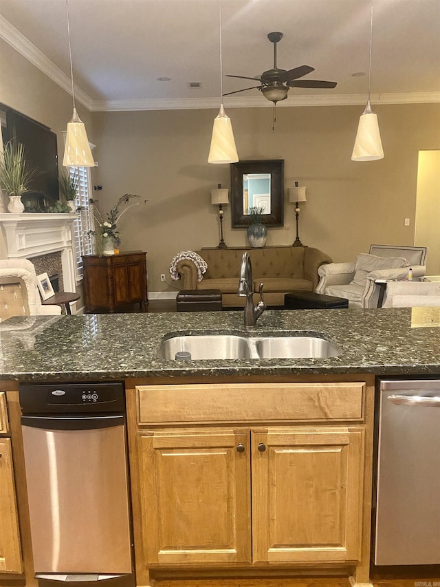 kitchen featuring hanging light fixtures, stainless steel dishwasher, sink, and dark stone counters