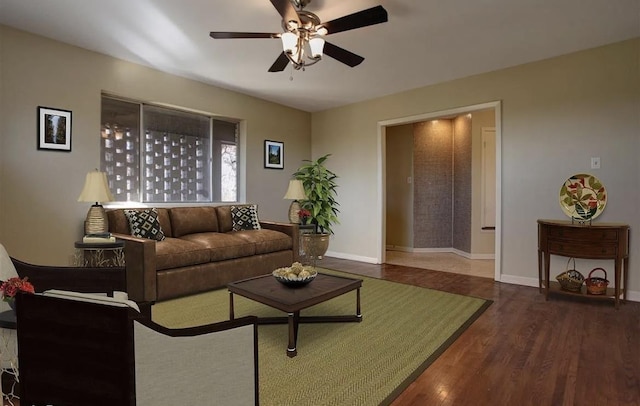 living room with dark wood-type flooring and ceiling fan