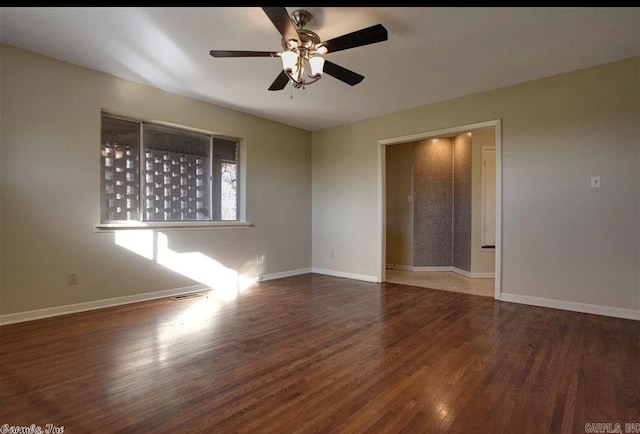 empty room featuring dark wood-type flooring and ceiling fan