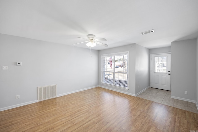 foyer entrance with ceiling fan and light wood-type flooring