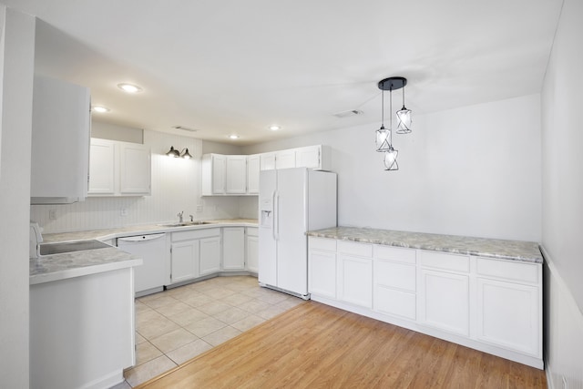 kitchen with white cabinetry, sink, white appliances, and decorative light fixtures