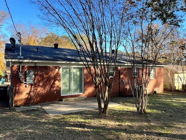 rear view of house featuring a patio and a lawn