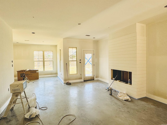 foyer entrance featuring a fireplace and concrete floors