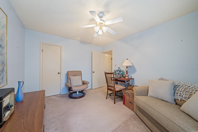 home office featuring ceiling fan, light carpet, and a textured ceiling