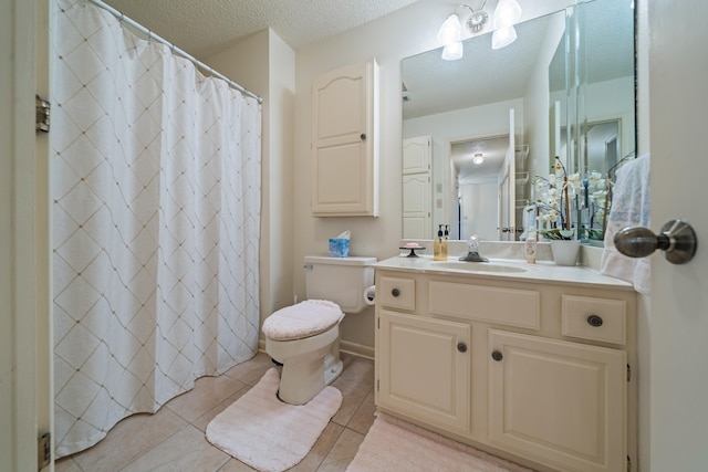 bathroom featuring tile patterned floors, toilet, vanity, and a textured ceiling