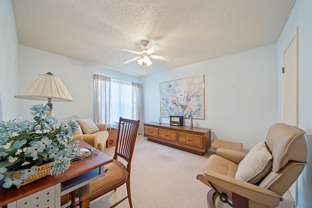 office space featuring light colored carpet, a textured ceiling, and ceiling fan