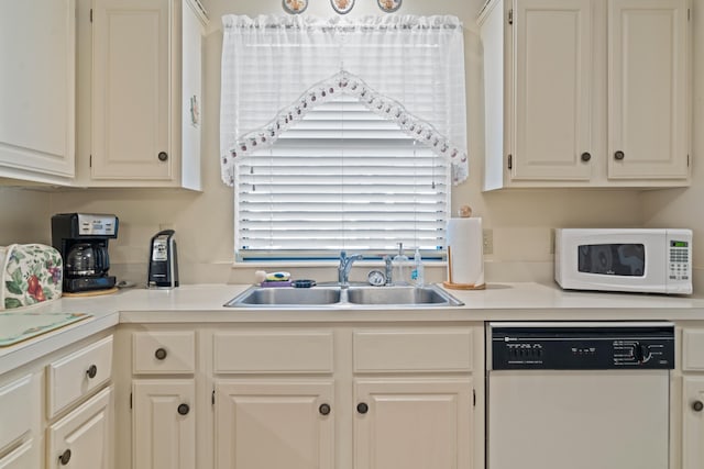 kitchen with white appliances, sink, and white cabinets