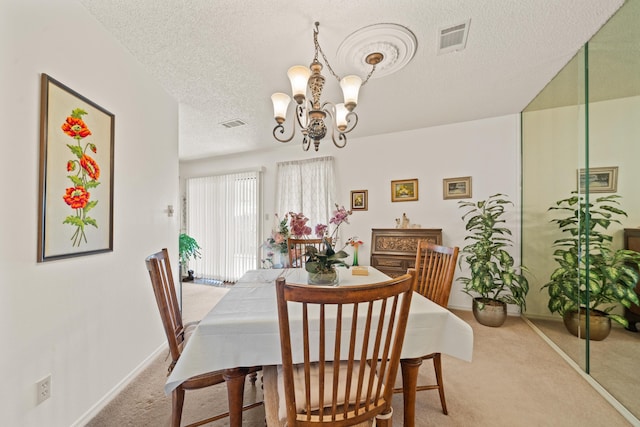 dining area featuring a notable chandelier, carpet floors, and a textured ceiling