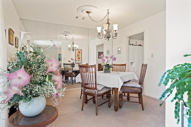 carpeted dining space featuring a notable chandelier and a textured ceiling