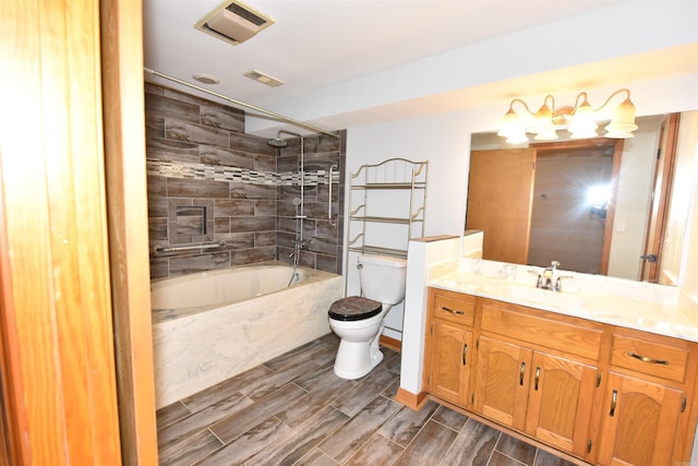 full bathroom with vanity, tiled shower / bath combo, and toilet