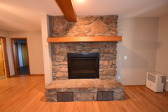 interior details featuring beamed ceiling, wood-type flooring, and a fireplace