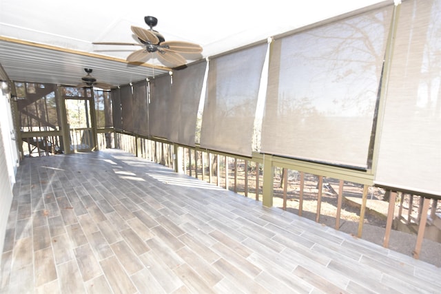 unfurnished sunroom with ceiling fan