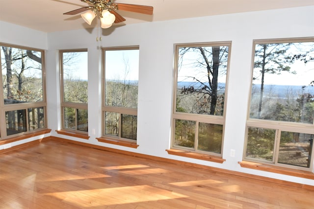 unfurnished sunroom featuring a wealth of natural light and ceiling fan