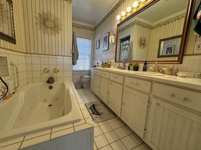 bathroom featuring a bathtub, vanity, toilet, crown molding, and tile patterned floors