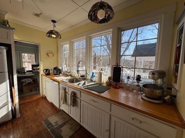 kitchen with dishwasher, butcher block counters, white cabinets, hanging light fixtures, and dark wood-type flooring