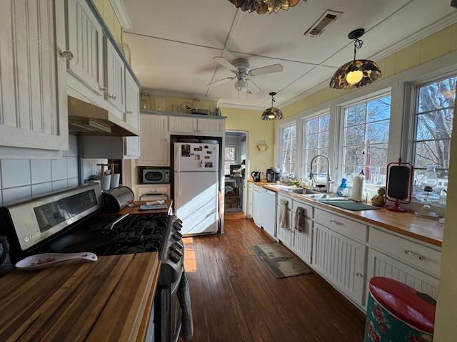 kitchen featuring pendant lighting, white cabinets, and white appliances