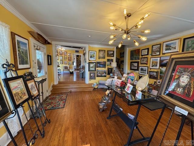 home office with hardwood / wood-style flooring, ornamental molding, and an inviting chandelier