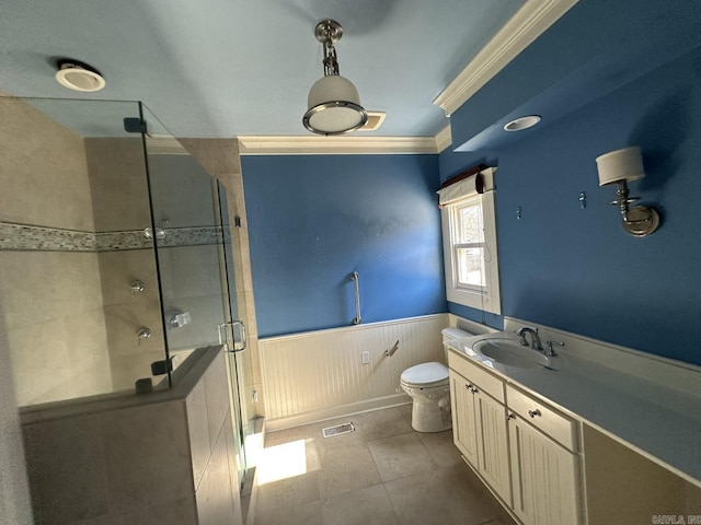 bathroom with a shower with shower door, tile patterned flooring, vanity, toilet, and crown molding