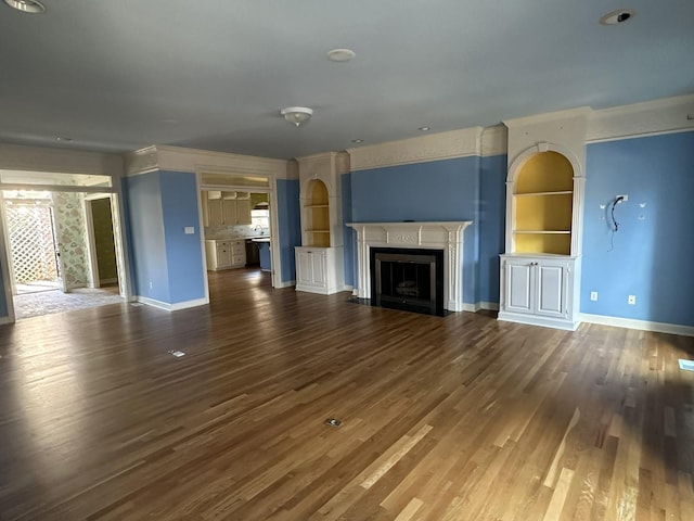 unfurnished living room featuring built in shelves and dark hardwood / wood-style flooring