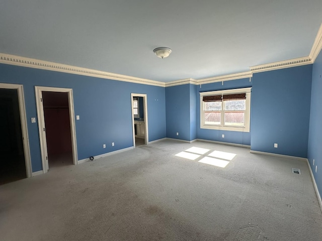 spare room featuring ornamental molding and light carpet