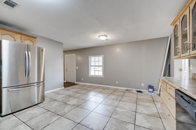 kitchen featuring dishwasher, light brown cabinets, stainless steel refrigerator, and light tile patterned flooring