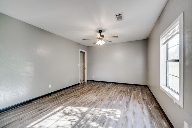 unfurnished room featuring light hardwood / wood-style flooring, a wealth of natural light, and ceiling fan