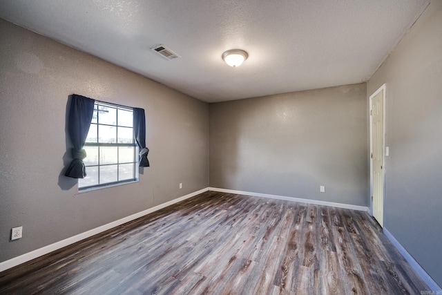 spare room with hardwood / wood-style flooring and a textured ceiling