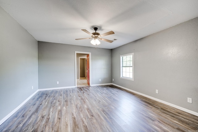 empty room with hardwood / wood-style floors, a textured ceiling, and ceiling fan