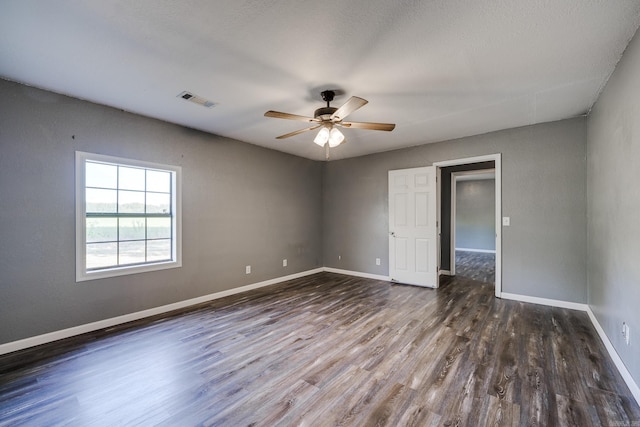 spare room with ceiling fan and dark hardwood / wood-style flooring