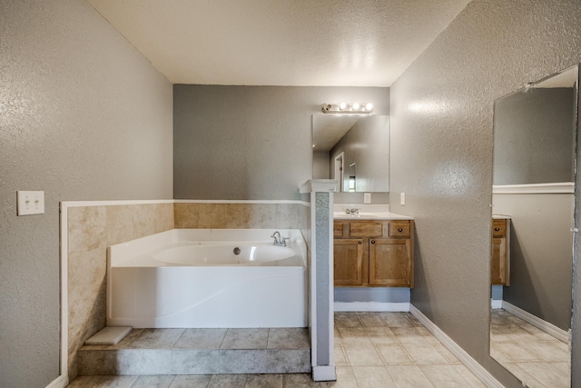 bathroom featuring vanity, a tub, and a textured ceiling