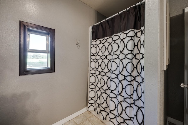 bathroom with tile patterned flooring and walk in shower