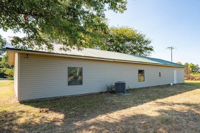 view of side of home with cooling unit and a lawn