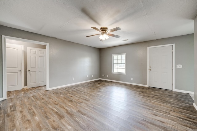 unfurnished room with a textured ceiling, light hardwood / wood-style floors, and ceiling fan