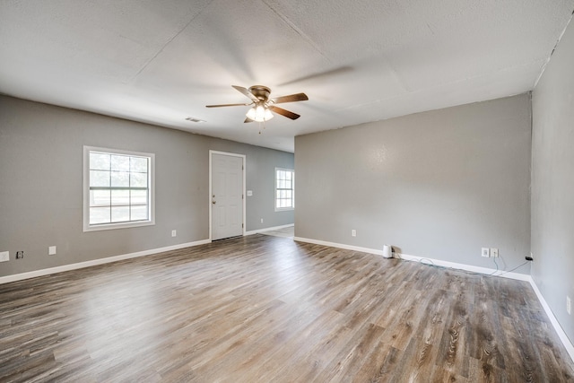 spare room featuring hardwood / wood-style flooring, plenty of natural light, a textured ceiling, and ceiling fan