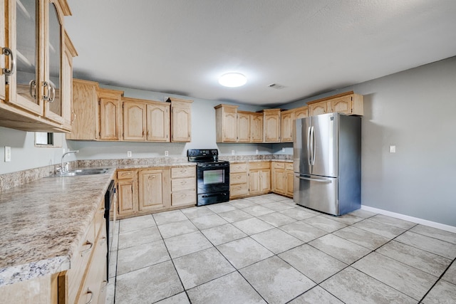 kitchen featuring sink, light brown cabinets, light tile patterned floors, and black appliances