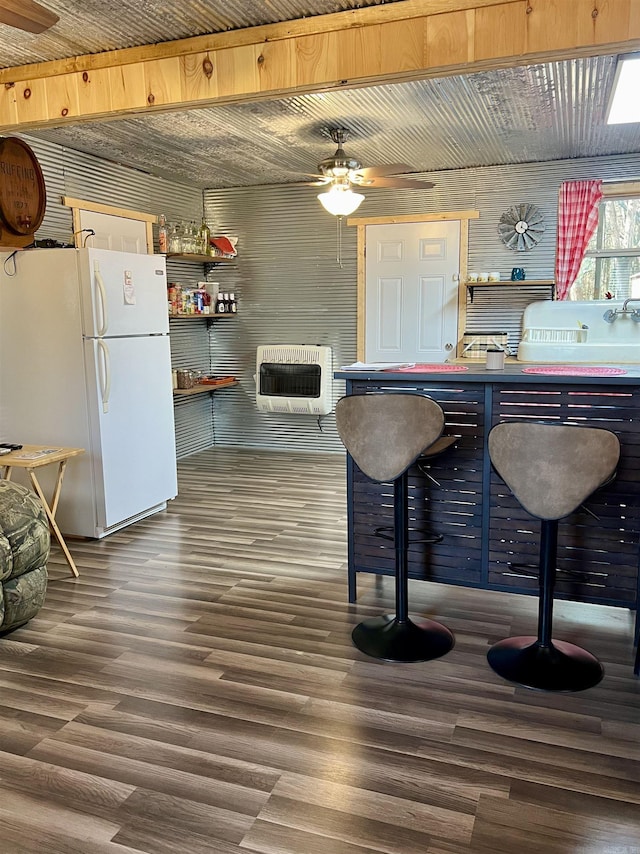 kitchen featuring white refrigerator, dark wood-type flooring, and heating unit