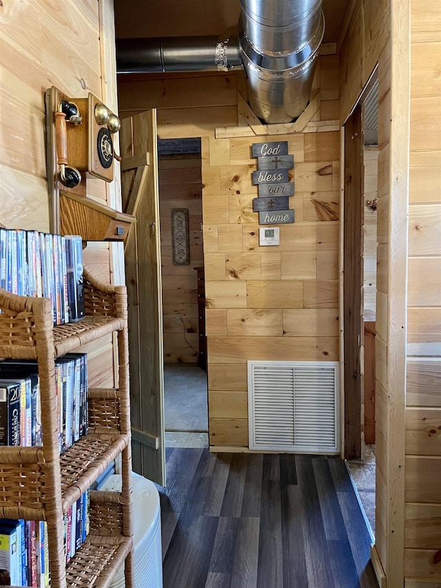 interior space with dark hardwood / wood-style flooring and wood walls