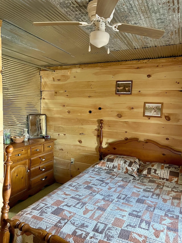 bedroom with ceiling fan, wood ceiling, and wood walls