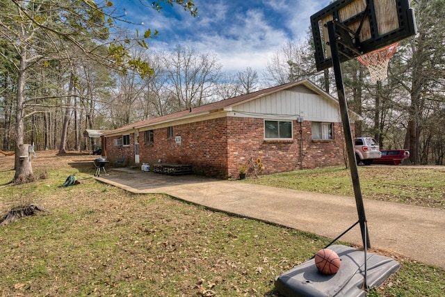 view of side of home with a yard and a patio