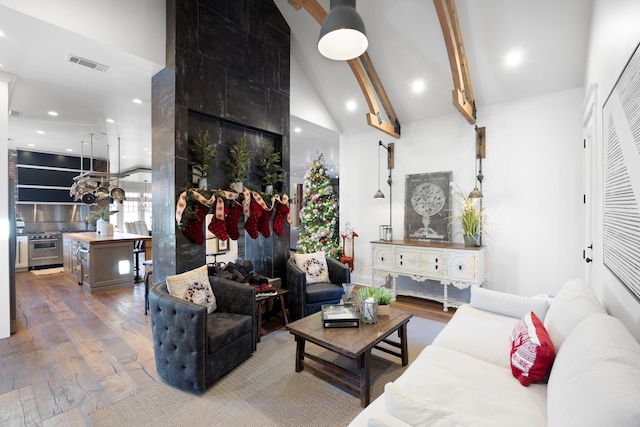 living room with beam ceiling, wood-type flooring, and high vaulted ceiling