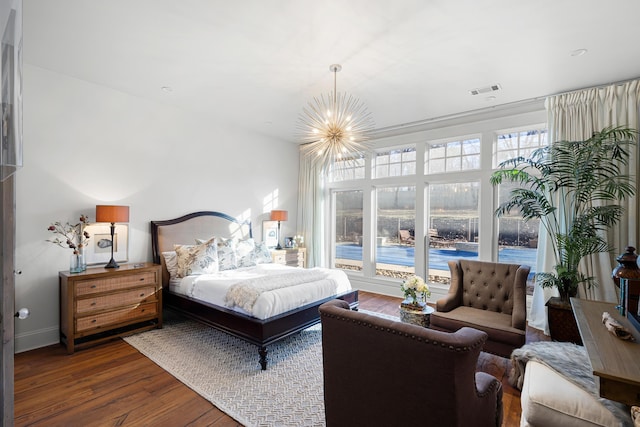 bedroom featuring dark hardwood / wood-style flooring and a notable chandelier