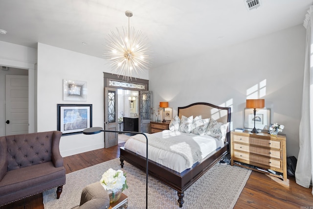 bedroom featuring dark hardwood / wood-style flooring and an inviting chandelier