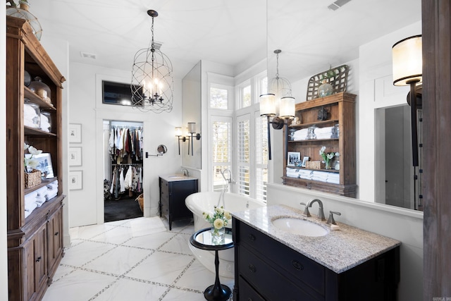 bathroom featuring vanity, a bath, and a chandelier