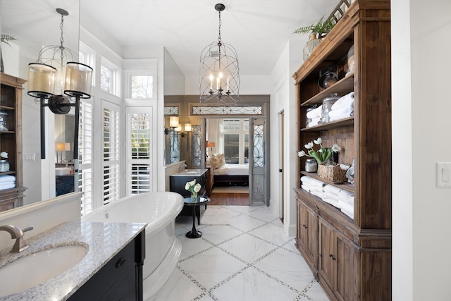 bathroom with vanity, a bathing tub, and a chandelier