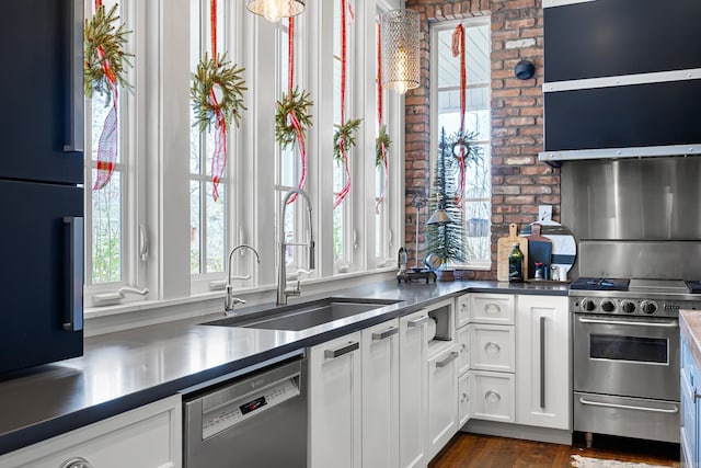 kitchen with dark wood-type flooring, appliances with stainless steel finishes, sink, and white cabinets