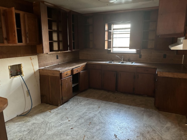 kitchen featuring dark brown cabinets, sink, and wall chimney range hood